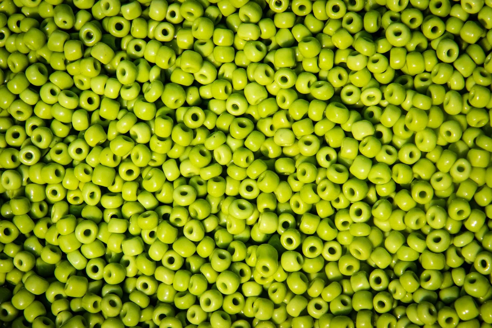 A close-up of vibrant green beads, perfect for art and crafts projects, showcasing rich color and texture.